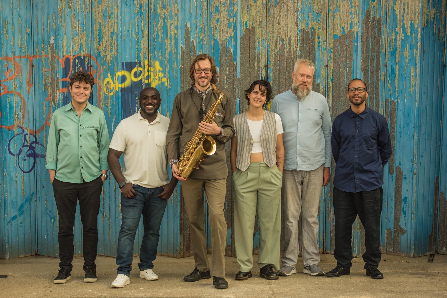 Man with saxophone standing with other people